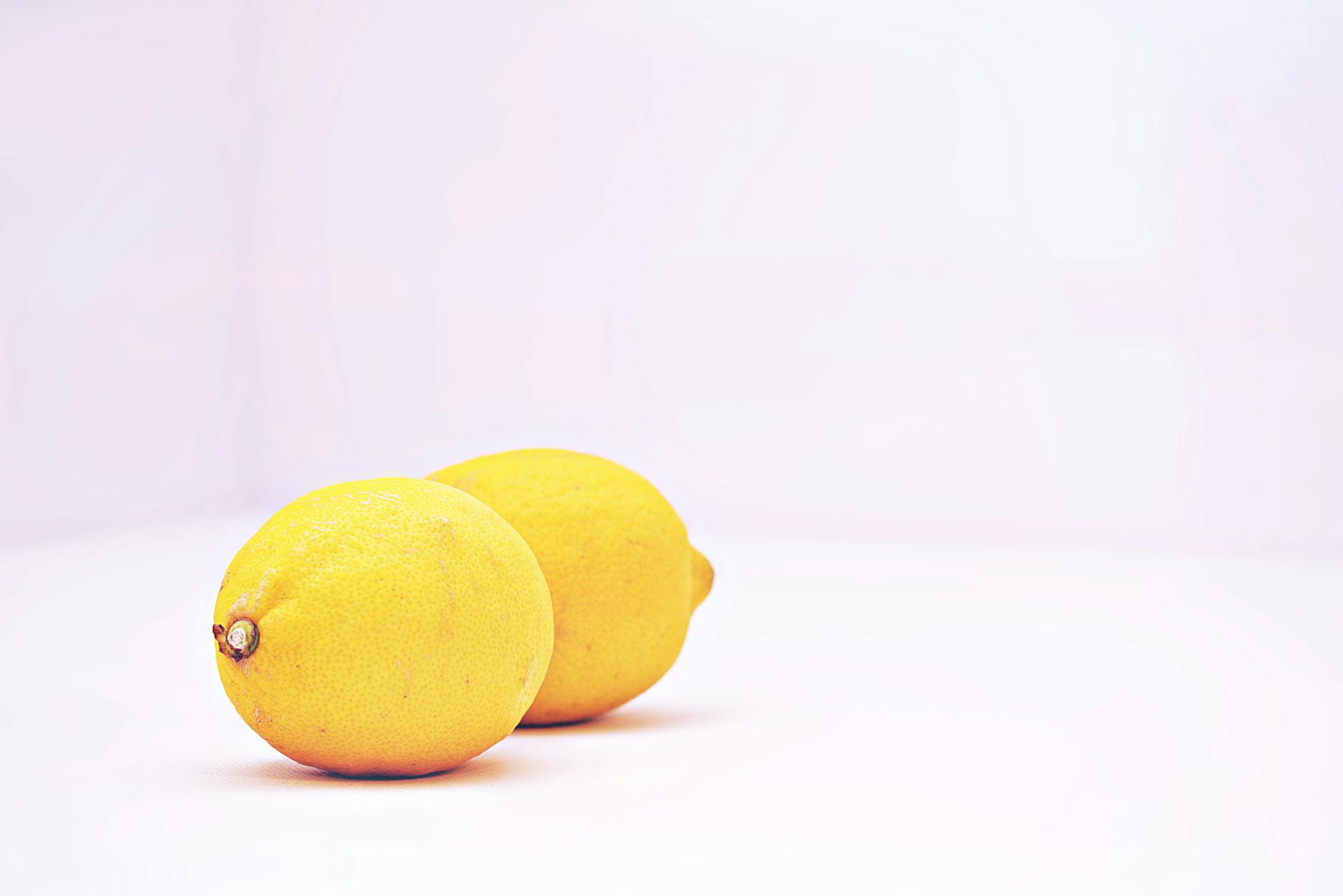 Two vibrant lemons against a white background, evoking the design of air-suction clitoral vibrators
