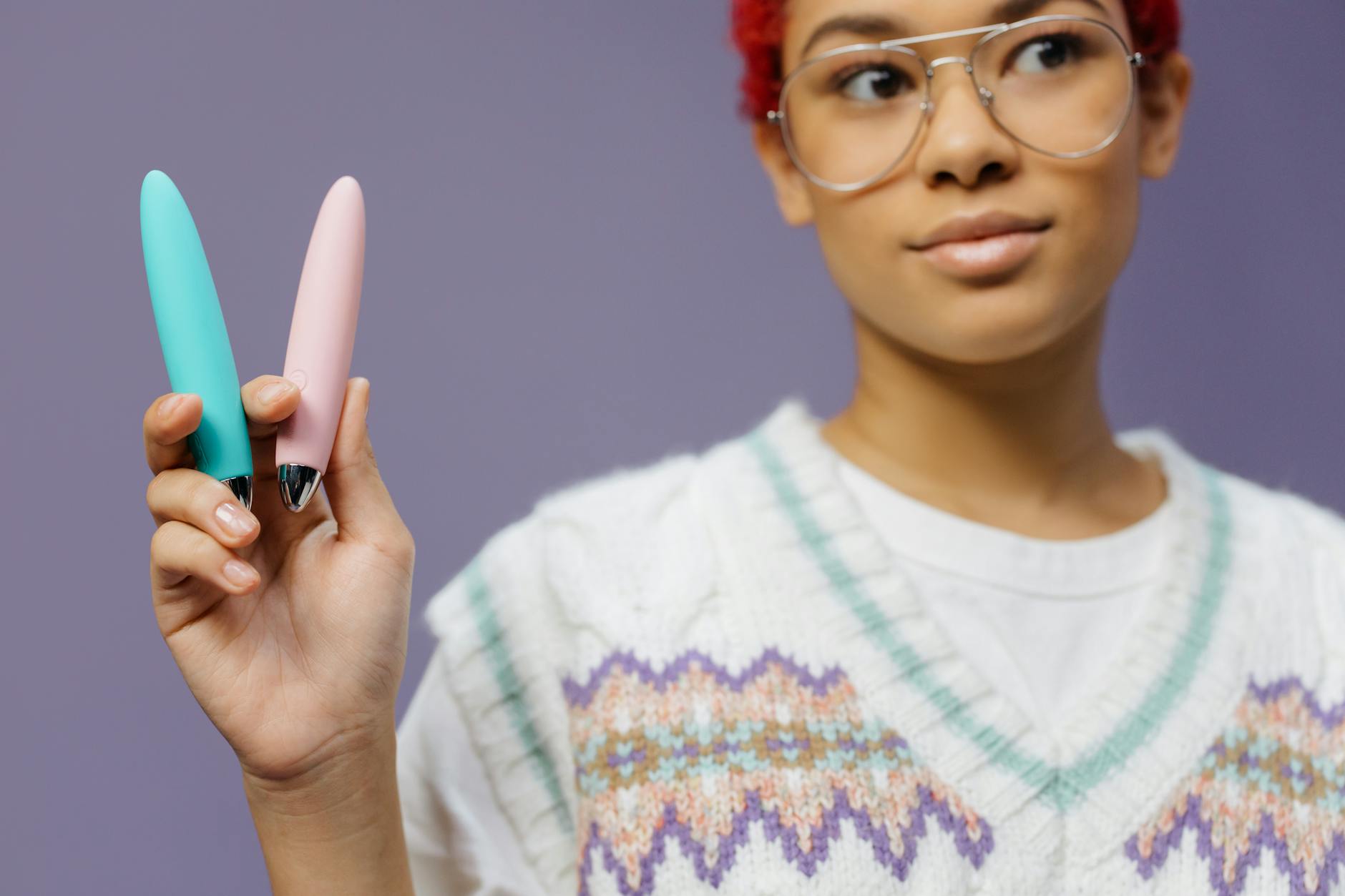 Woman holding a lemon clitoral vibrator against a purple background, representing pleasure without pressure.