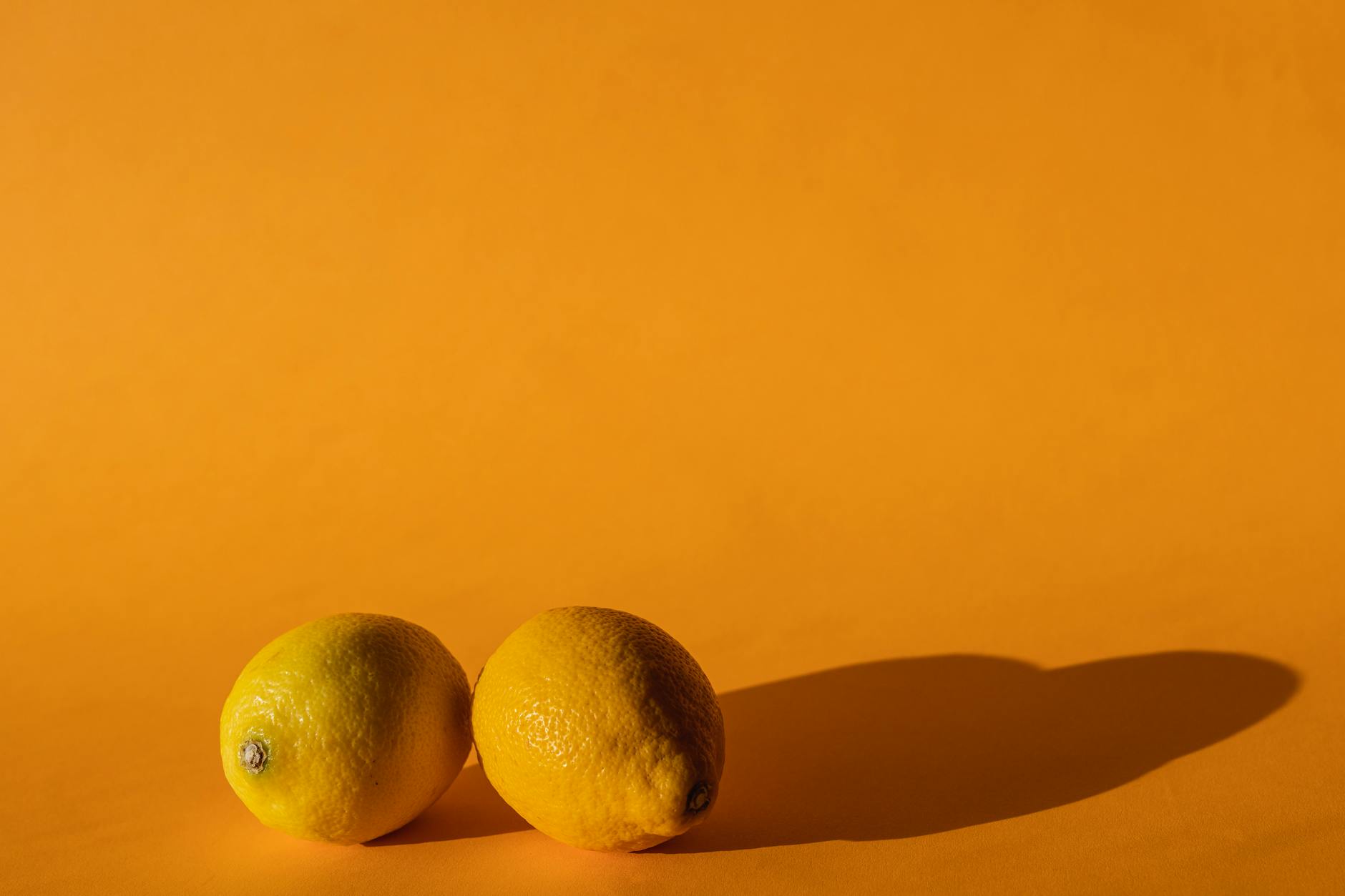 Ripe vivid lemons composed on yellow background, symbolizing the fresh, energizing design of Hello Nancy lemon vibrators