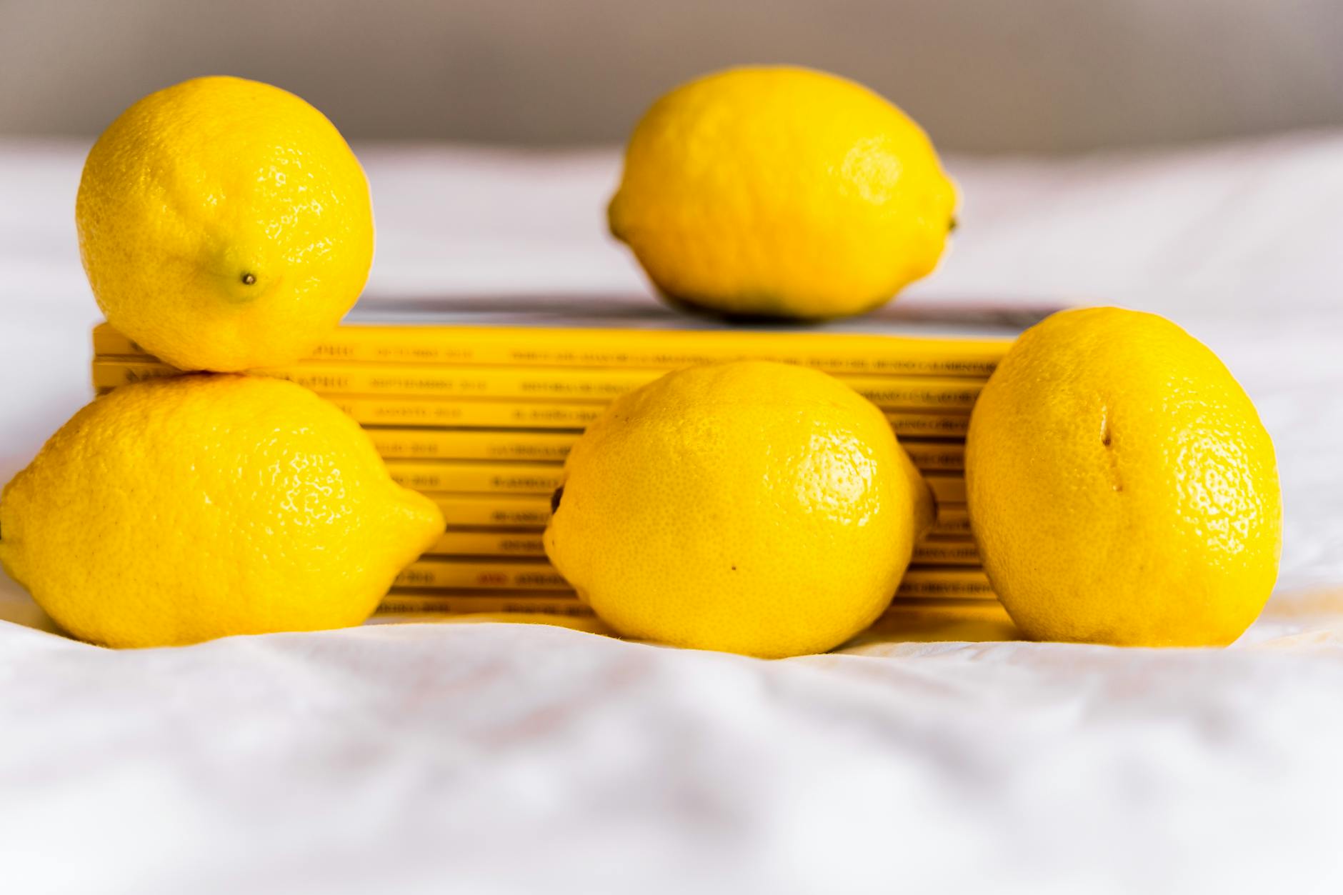 A sleek yellow clitoral vibrator on white silk, representing lemon vibrators designed for solo exploration